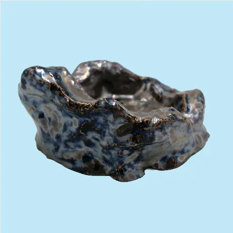 Un socle en céramique sculpté à la main, émaillé de bleu et d’ambre